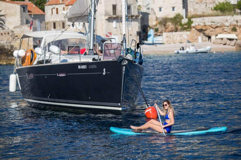 paddleboarding near a yacht